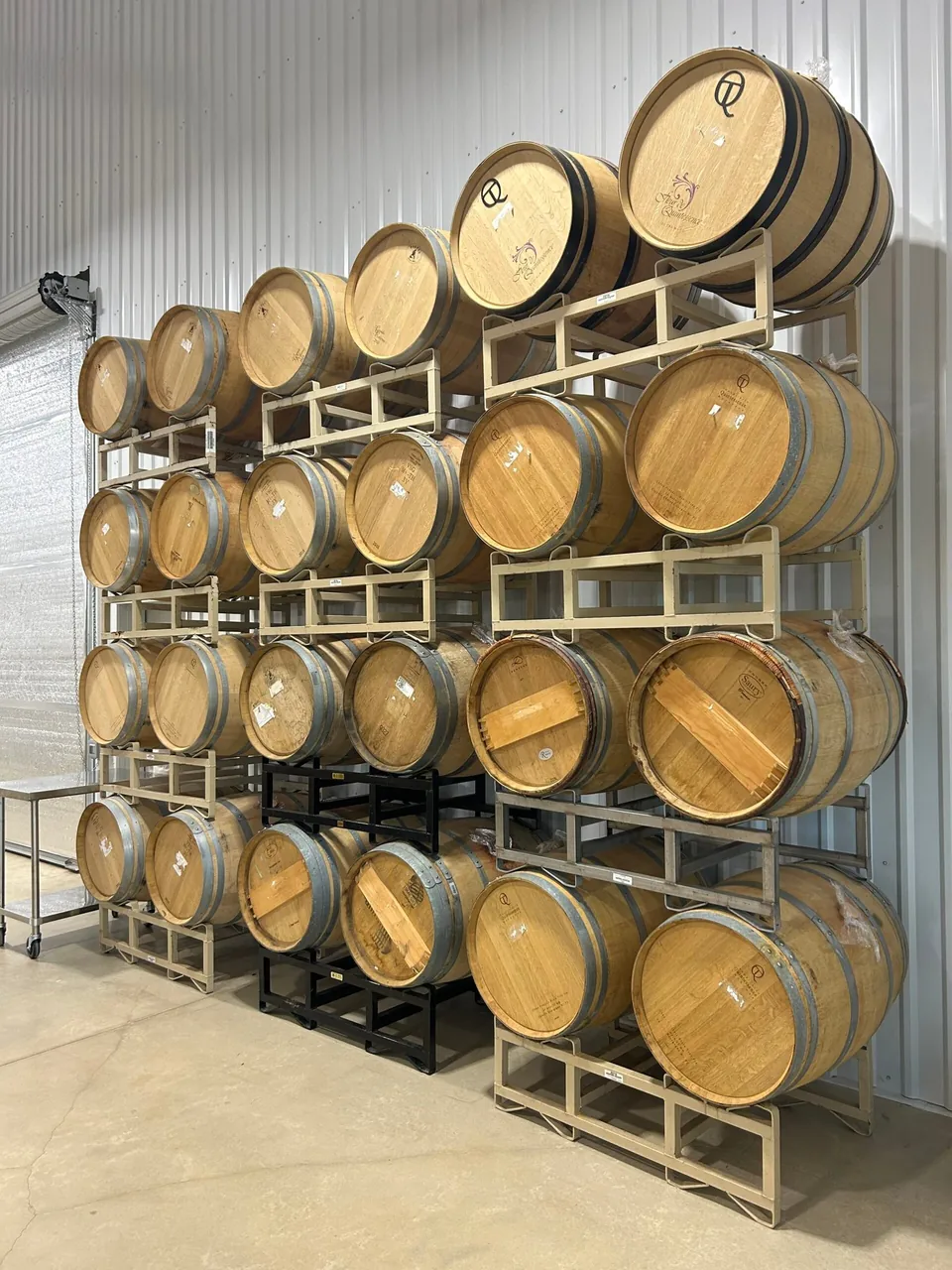 Stacked oak barrels in a Texas Hill Country winery barrel room.