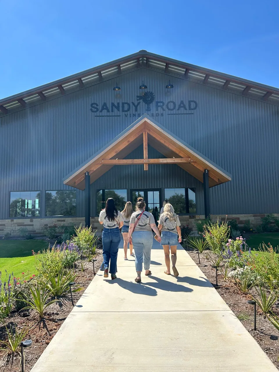 Guests walking up the path to a Hill Country winery tasting room.